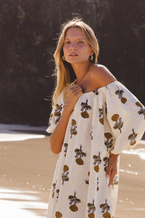 Dahlia Maxi Dress Marigold — upper body portrait off-shoulder showing billowy sleeve detail, white linen with bold marigold hand block print floral motif | Daughters of India