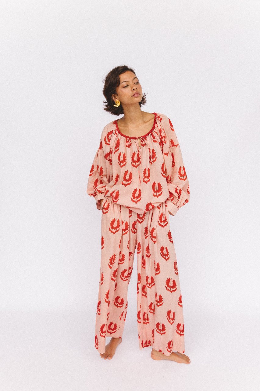 Ria Pants Cherry Blossom — studio lower body detail, model wearing cherry blossom hand block print cotton wide-leg pants, pink floral motif on cream fabric, flowing silhouette, artisan Jaipur India | Daughters of India